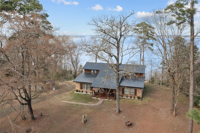 view of front of home featuring metal roof and brick siding