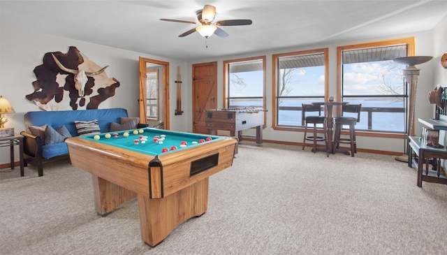 game room with light carpet, billiards, baseboards, a ceiling fan, and a water view