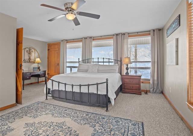 bedroom featuring a ceiling fan, multiple windows, baseboards, and carpet flooring