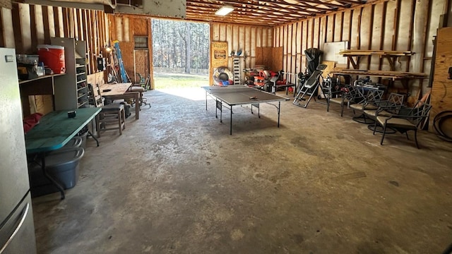 rec room with a garage and unfinished concrete flooring