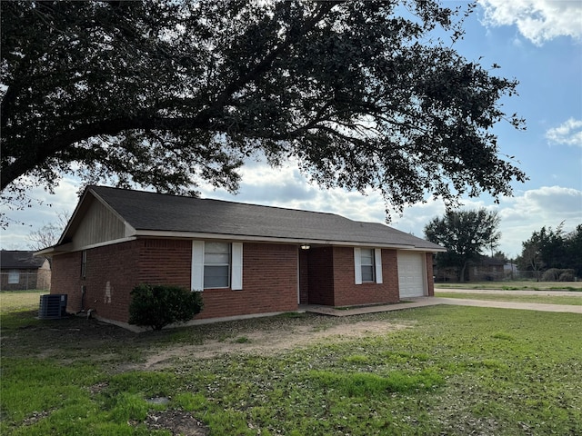 single story home with cooling unit, a garage, and a front yard