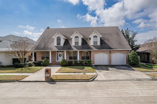 cape cod-style house with a garage and a front lawn