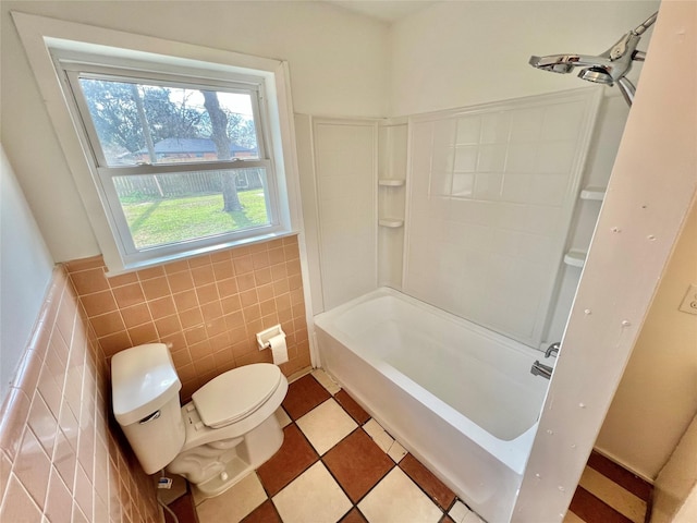 bathroom with toilet, tile walls, and shower / bathing tub combination