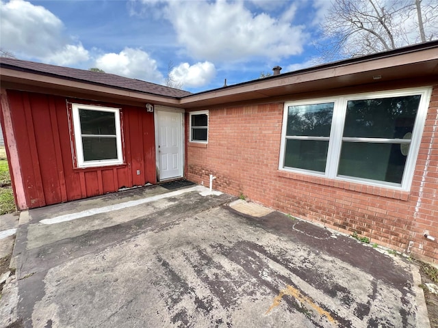 view of exterior entry with a patio