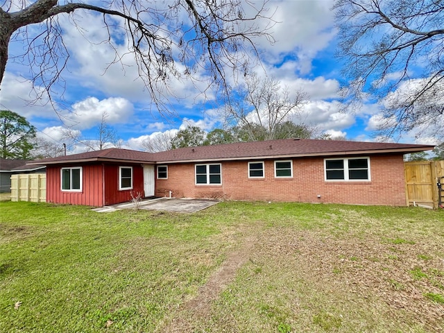 back of house with a patio and a lawn