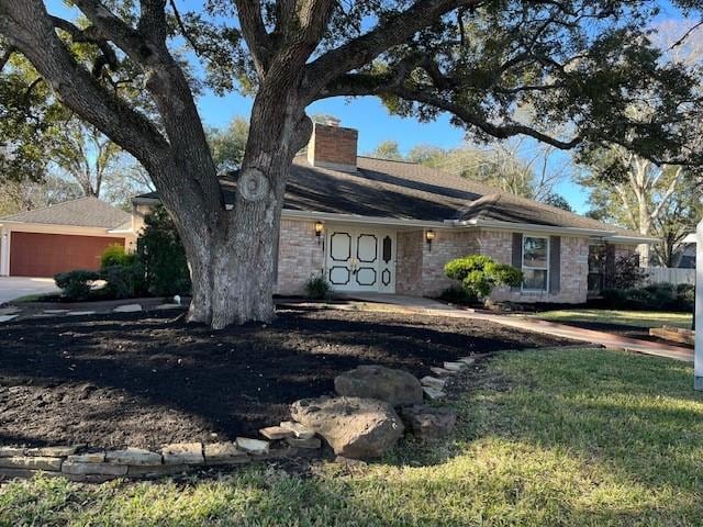 view of front of property featuring a garage, a front yard, and a chimney