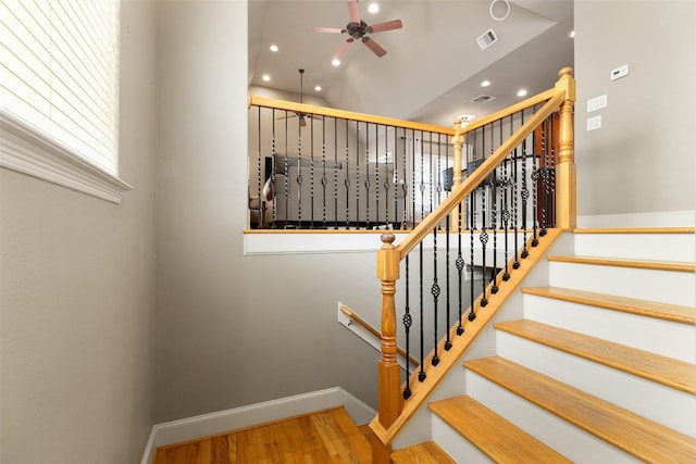 stairway with hardwood / wood-style floors and ceiling fan