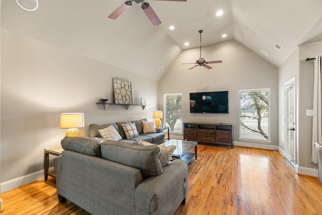 living room with high vaulted ceiling, ceiling fan, and light wood-type flooring