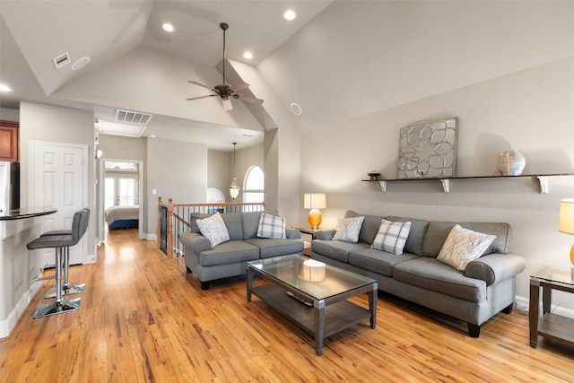 living room featuring ceiling fan, high vaulted ceiling, and light wood-type flooring