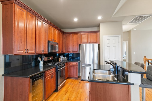 kitchen featuring stainless steel appliances, sink, beverage cooler, and light wood-type flooring