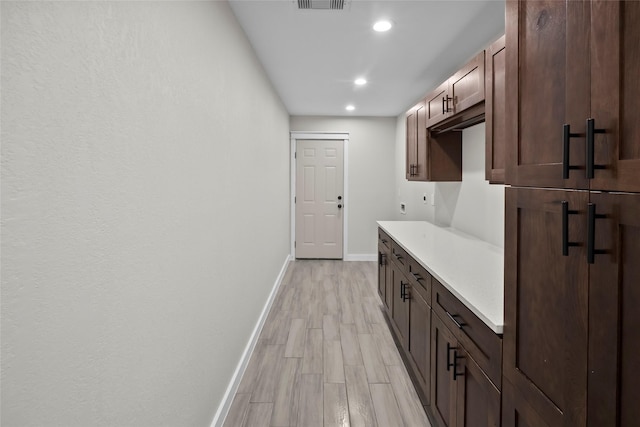 interior space featuring dark brown cabinetry and light hardwood / wood-style floors