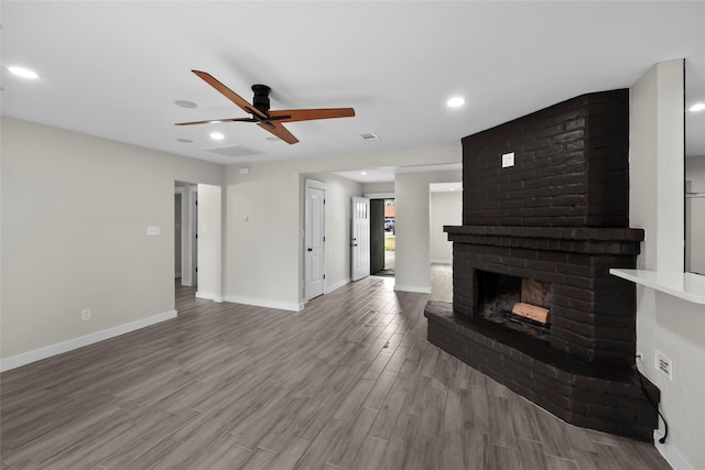 living room featuring a brick fireplace, ceiling fan, and light hardwood / wood-style flooring