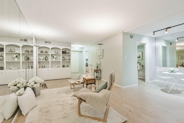 living room with track lighting and light wood-type flooring