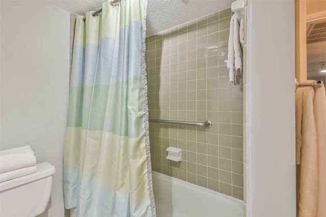 bathroom featuring shower / bathtub combination with curtain, a textured ceiling, and toilet