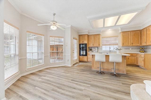 kitchen with decorative backsplash, a kitchen bar, a center island, and black microwave