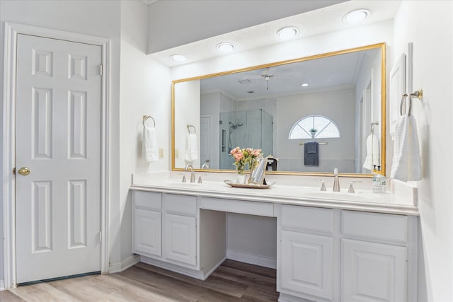 bathroom featuring a shower with door, vanity, wood-type flooring, and ornamental molding