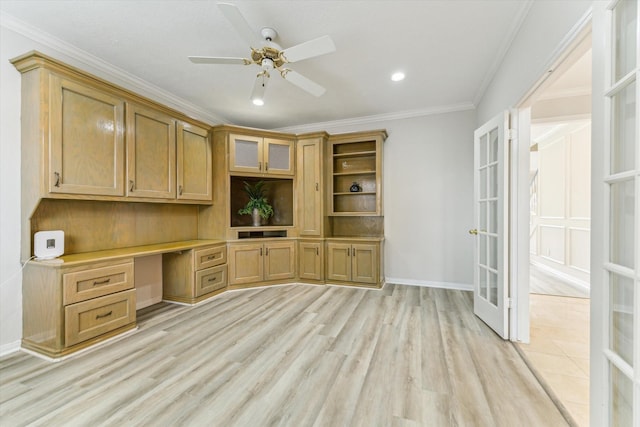 unfurnished office featuring ceiling fan, built in desk, ornamental molding, french doors, and light wood-type flooring