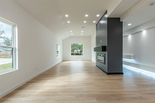 unfurnished living room featuring vaulted ceiling and light hardwood / wood-style flooring