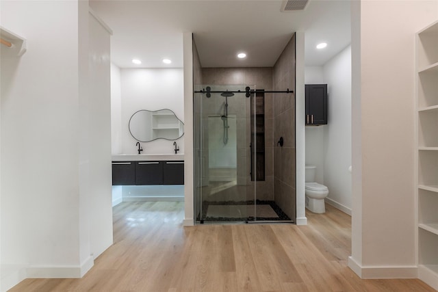 bathroom with vanity, toilet, an enclosed shower, and hardwood / wood-style floors