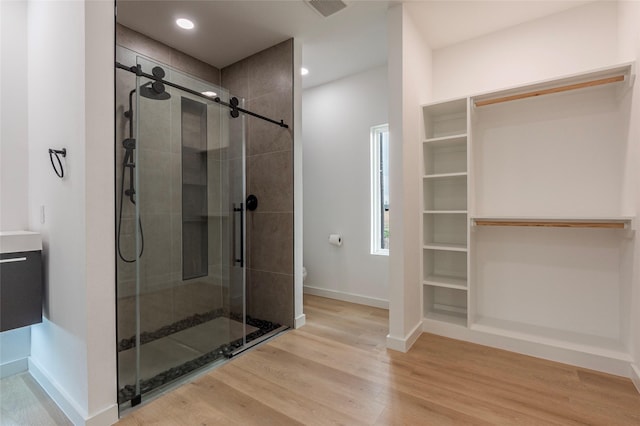 bathroom featuring an enclosed shower, wood-type flooring, and toilet