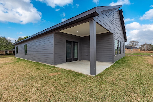 rear view of house featuring a patio and a yard