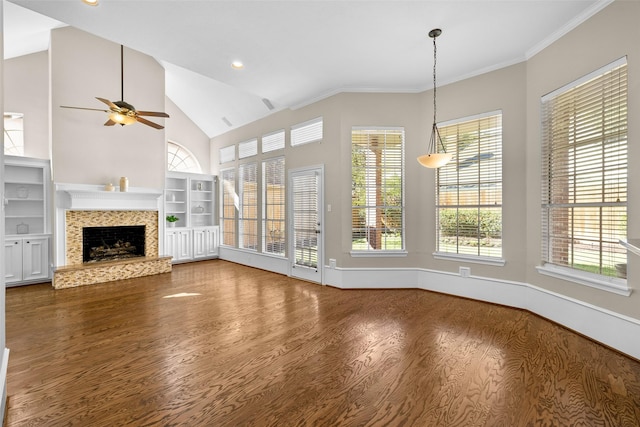 unfurnished living room with crown molding, wood-type flooring, built in features, ceiling fan, and a fireplace