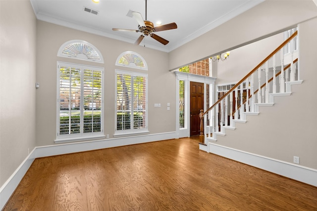 foyer entrance with crown molding, wood-type flooring, and ceiling fan