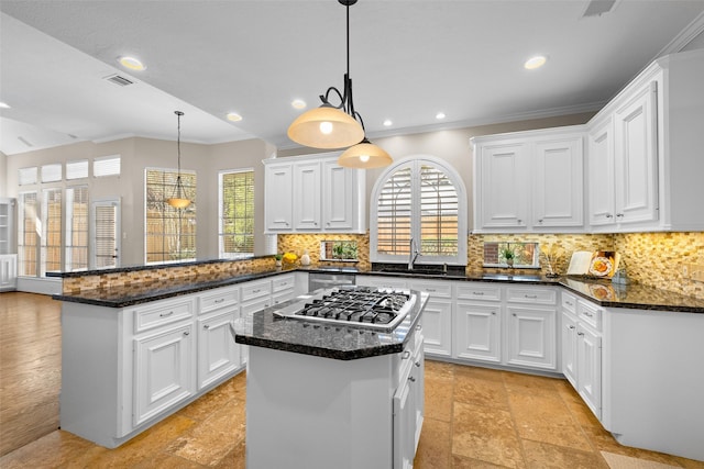 kitchen featuring white cabinetry, stainless steel gas stovetop, a center island, and kitchen peninsula