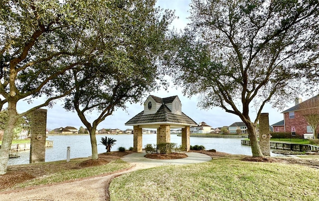 view of property's community with a water view, a yard, and a gazebo