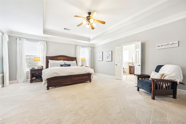 carpeted bedroom featuring ceiling fan, a raised ceiling, baseboards, visible vents, and ornamental molding