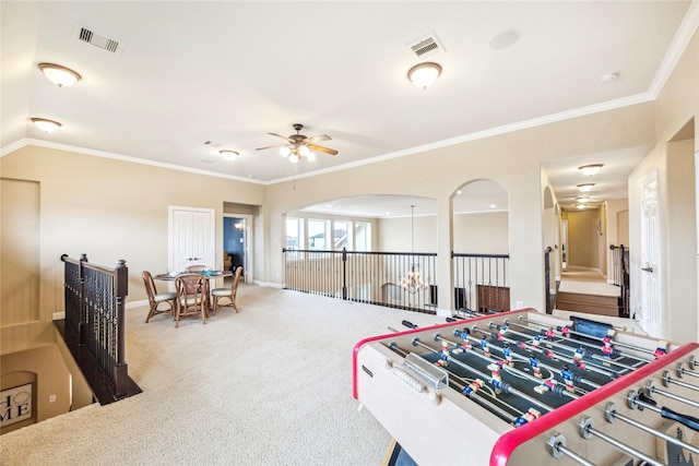 rec room with ornamental molding, a ceiling fan, carpet flooring, and visible vents
