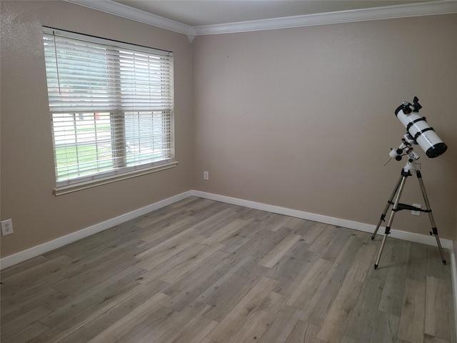 empty room with ornamental molding and light hardwood / wood-style floors