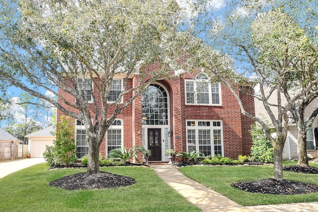 view of front of property featuring a garage, brick siding, and a front yard