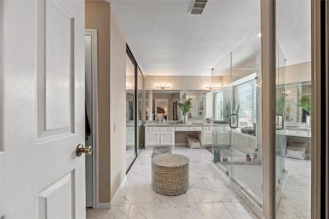 bathroom featuring vanity and a shower with door