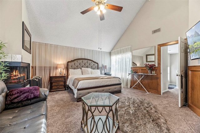 carpeted bedroom featuring a textured ceiling, high vaulted ceiling, and ceiling fan