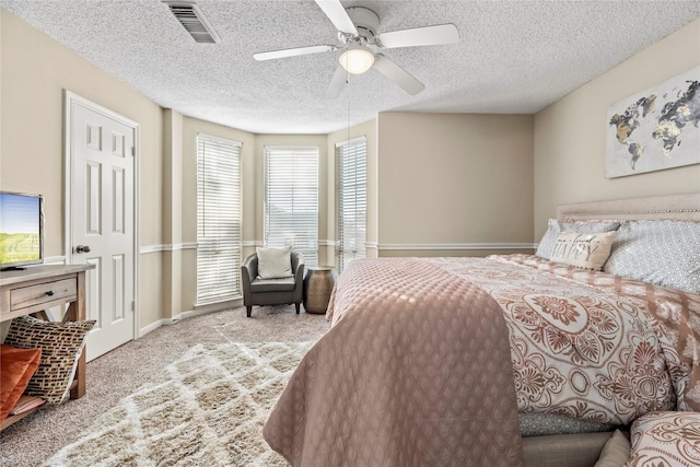 carpeted bedroom with ceiling fan and a textured ceiling