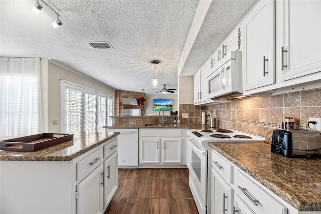 kitchen featuring decorative light fixtures, tasteful backsplash, sink, white cabinets, and white appliances