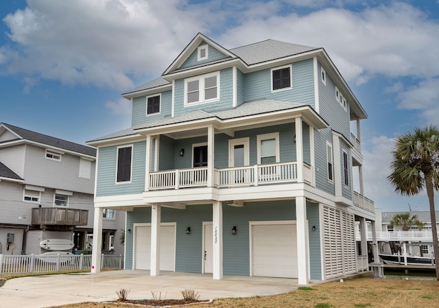 beach home with a garage and roof with shingles