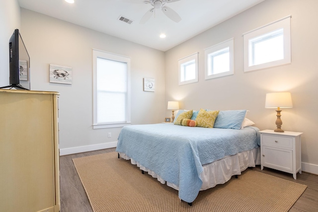 bedroom featuring dark wood-style flooring, multiple windows, visible vents, and baseboards