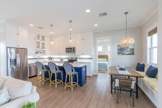 kitchen featuring stainless steel appliances, light countertops, open floor plan, and visible vents