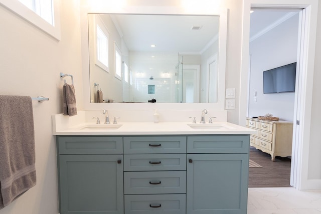 bathroom featuring crown molding, plenty of natural light, a sink, and a shower stall