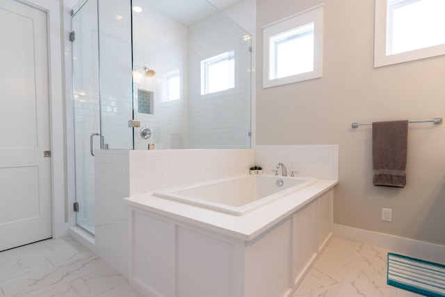 full bath with marble finish floor, baseboards, a garden tub, and a stall shower