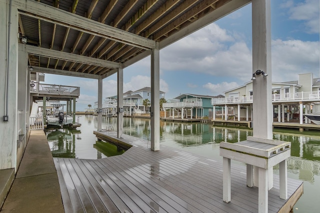 view of dock with a residential view and a water view