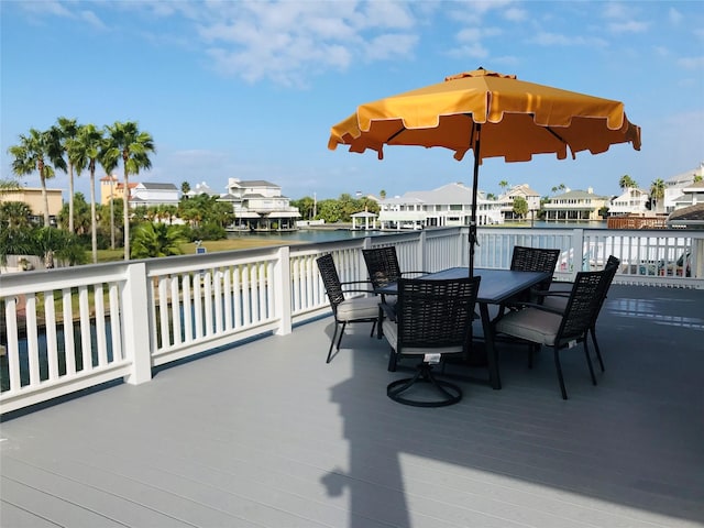 wooden terrace featuring outdoor dining area and a water view