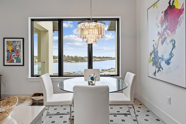 dining area with a water view and a notable chandelier