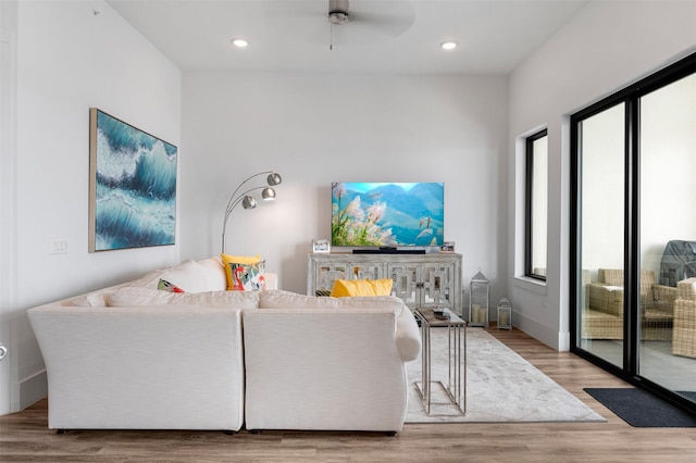 living room featuring light hardwood / wood-style flooring and ceiling fan