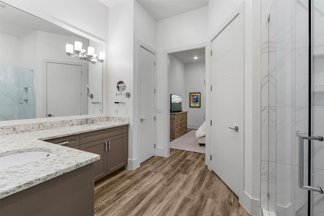 bathroom with vanity, hardwood / wood-style floors, a chandelier, and walk in shower