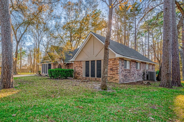 view of home's exterior featuring central AC unit, a yard, and a sunroom