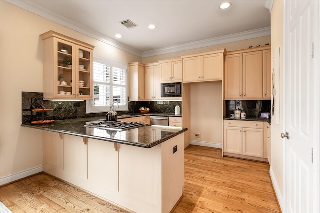 kitchen featuring appliances with stainless steel finishes, dark stone counters, light hardwood / wood-style floors, kitchen peninsula, and crown molding