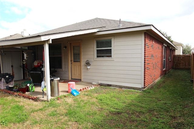 back of house featuring a patio and a lawn